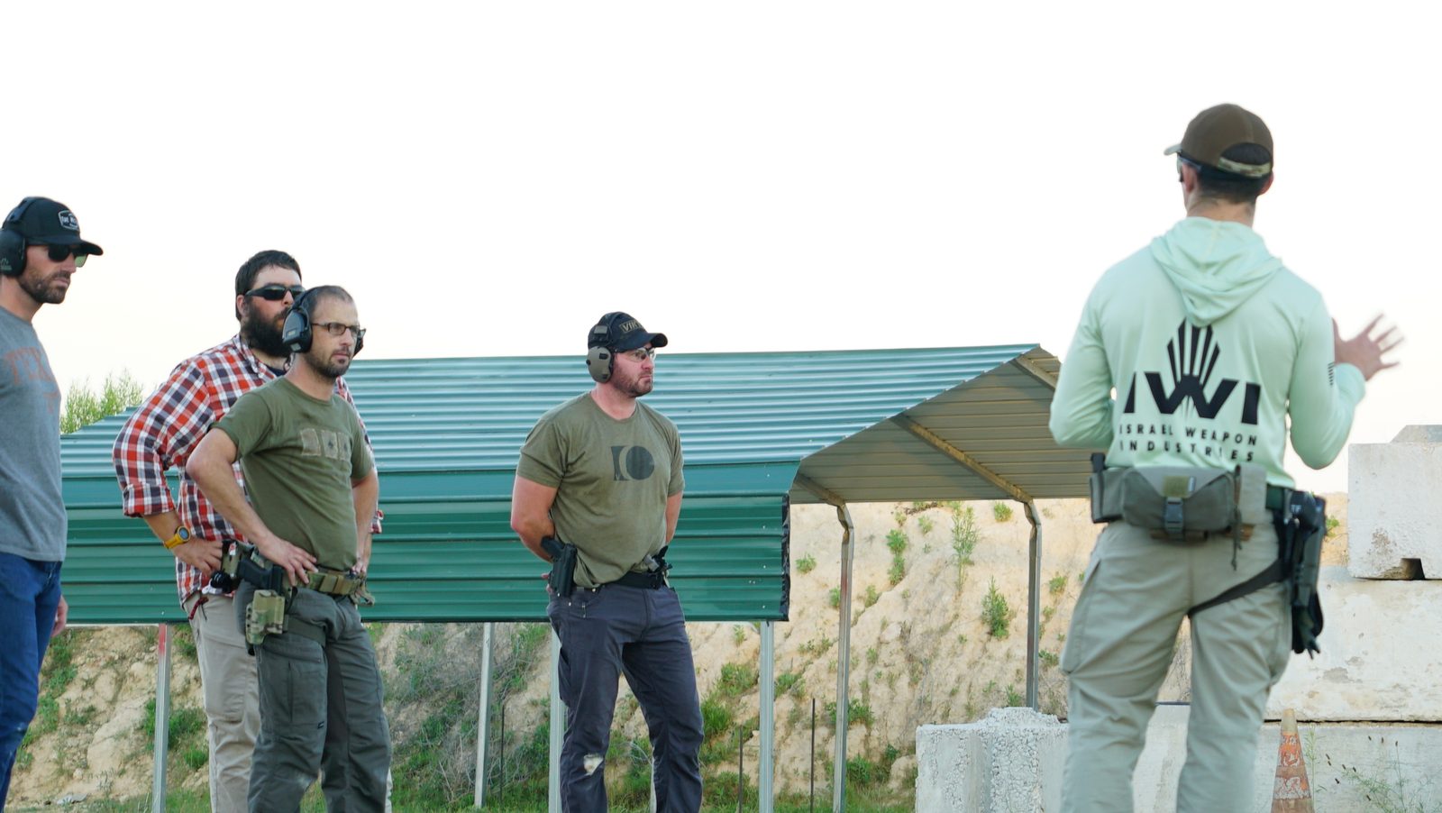 Instructor briefing corporate group before live fire at Tactical Fitness Austin outdoor range